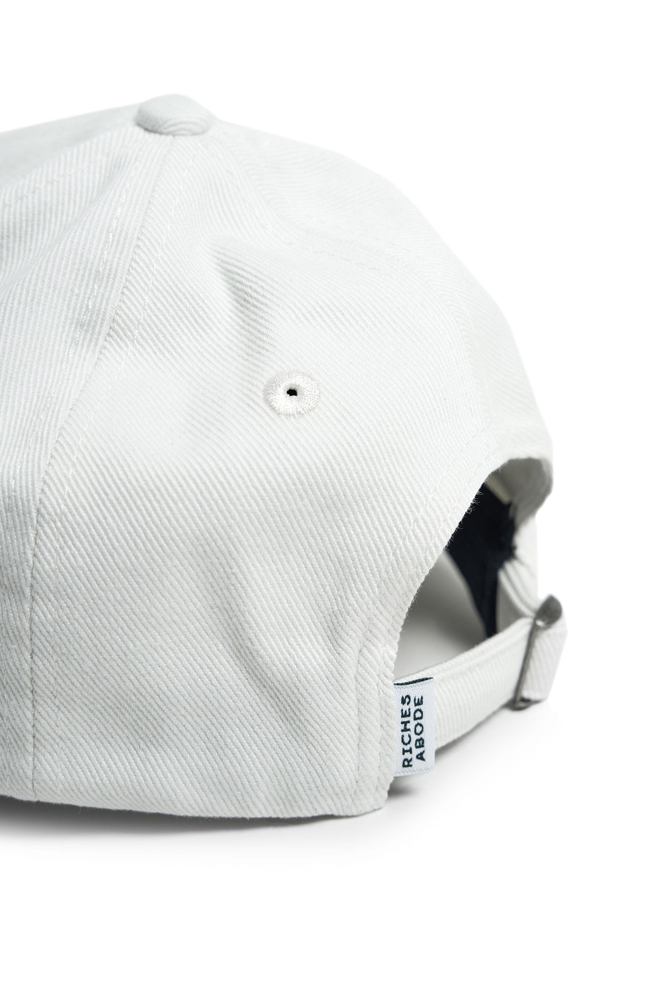Classic white baseball cap by Riches Abode, designed with sustainable, breathable materials. Perfect for sunny days and casual wear